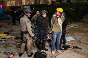 Una manifestante propalestina es detenida por la policía de Los Ángeles tras el desalojo del campamento estudiantil de la Universidad de California. Foto AFP.