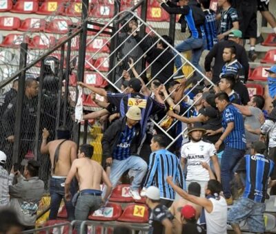 Aficionados chocan durante un partido de la liga mexicana de fútbol entre el anfitrión Querétaro y Atlas de Guadalajara, en el estadio Corregidora, en Querétaro, México, el sábado 5 de marzo de 2022. Sergio González / AP